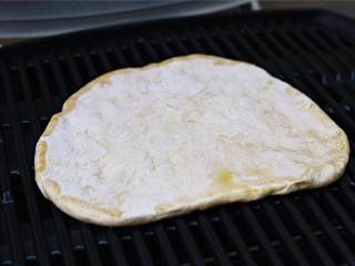 4、玛格丽特披萨,将面团放在烤架上，刷油的一面朝下，中火烤5分钟。