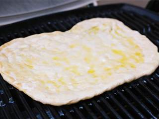 5、玛格丽特披萨,在朝上的一面刷上剩余的特级初榨橄榄油 。