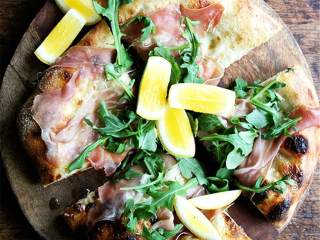 8、芝麻菜熏火腿披萨,淋上橄榄油，撒上海盐，搭配柠檬 一起享用。