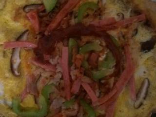 3、鸡蛋披萨,锅油少许……鸡蛋放下去……摊平……八分熟……把青椒～蘑菇～香肠铺在鸡蛋上……关火闷熟