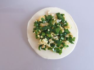 3、饺皮双层饼,取一个饺子皮上面放上馅，把四周留出来