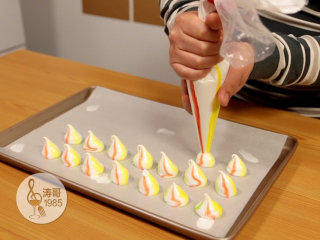 15、彩虹蛋白饼干，外形可爱，口感入口即化,挤到颜色出来就可以往铺了烘焙纸的烤盘上挤了，裱花袋口要比烤盘高2厘米左右，裱花袋一定要垂直着往下挤，在收尾的时候就不要用力了