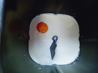 2、蔓越莓吐司面包,首先将牛奶倒入面包桶，再加入鸡蛋，糖和盐对角放。