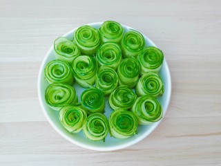 12、凉拌黄瓜卷,把卷好的黄瓜卷放到盘子里。
