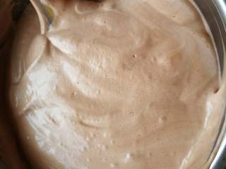 10、巧克力裸蛋糕,用软刮刀取三分之一蛋白糊放入蛋黄糊中,用翻拌的方式拌匀,就像炒菜那样从底部往上翻,千万别划圈搅拌,否则会消泡。翻拌一下,转动一下盆子。按这个方法翻拌均匀,把翻拌好的面糊倒入剩余的蛋白糊盆中继续翻拌好。