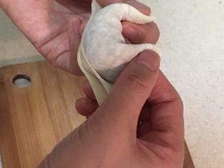 5、水饺,大拇指和食指继续捏住饺皮向后翻。