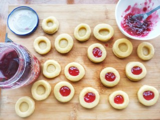 12、红心闪耀的覆盆子果酱甜心小圆饼~,这时可以去预热烤箱，并且用勺子把覆盆子果酱装入中心的空洞里，小心点，不要洒出来了，