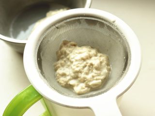 3、凉皮,找一个细而高的容器,把洗出来的淀粉水过滤进容器里,继续重复洗面过程,过滤出淀粉水。