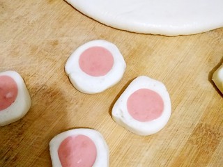 11、花边双拼披萨,然后把包裹好火腿肠的面切成自己需要的厚度，做成花边