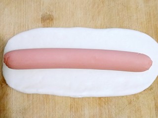 10、花边双拼披萨,剩下三分之一压扁擀成长条状，把火腿肠包裹进去