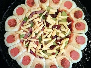 16、花边双拼披萨,然后在最上面撒上切好的芝士碎，加盖继续，中小火，焖至芝士碎全部融化。