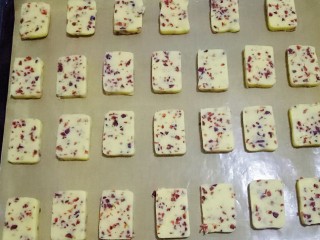 13、蔓越莓饼干,烤盘中铺上油纸，摆放在烤盘上，饼干之间留些空隙，以免烤的时候体积膨胀粘在一起