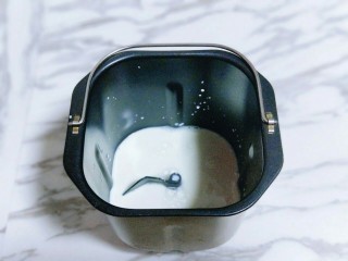 1、香葱培根芝士面包,首先将牛奶放入面包桶中。