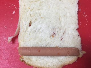 2、黄金吐司卷,吐司去掉四边的硬边，最下面放上火腿。