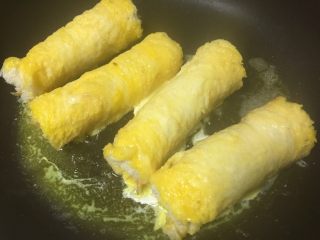 7、黄金吐司卷,放入锅中中火煎制。