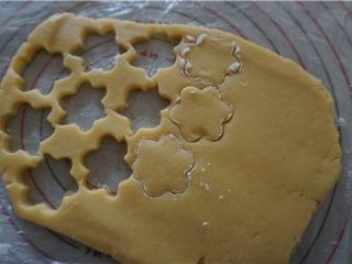 13、好吃的切达芝士酥饼,饼干模沾少许的干粉在面片上压出花型来，剩余的面团拢到一起折叠按压再次擀开重复压出花型