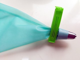 5、提拉米苏曲奇饼干,裱花嘴装入裱花袋,下面用夹子夹住