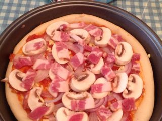 3、培根披萨,蘑菇培根片如图均匀摆好，烤箱预热200度上下火烤10分钟后
