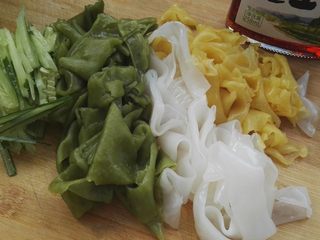 8、自做快手彩色凉皮,把凉皮放案板上切成条，黄瓜切丝。