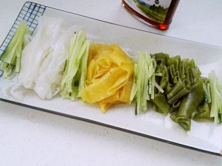 12、自做快手彩色凉皮,把三色凉皮、黄瓜丝放盘中。