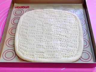 10、黑椒牛肉披萨,大面团擀成正方形，放入垫有油纸的烤盘中，同样叉出不规则的洞洞。