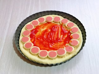 14、黑椒牛肉披萨,我先做的7寸，将切好的火腿片摆放在一圈，底涂上番茄酱，撒上一层芝士碎。