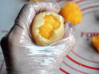 20、金沙奶黄月饼,慢慢用虎口往上推，捏紧收口，轻轻搓圆。