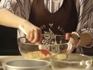 1、樱花芝士蛋糕,饼干放入保鲜袋中，用擀面棍一点点将饼干擀碎，黄油放入小碗中隔热水融化，倒入盆中与手指饼干粉末搅拌均匀