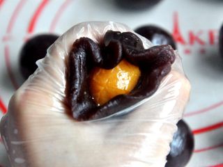 9、豆沙蛋黄月饼,用豆沙把蛋黄包住，搓成圆球。