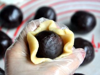 11、豆沙蛋黄月饼,把皮压薄，包裹馅，用虎口一点点把饼皮慢慢的推上去。
