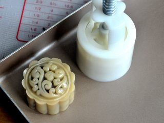13、豆沙蛋黄月饼,将包好的月饼放入50克的月饼模中，轻轻一压，月饼的雏形就有了。