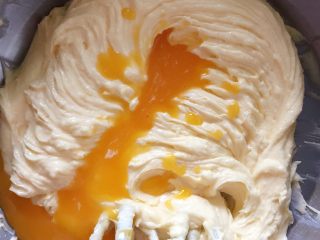 5、葡萄干奶酥,蛋黄打散分多次加入，用打蛋器搅打均匀。