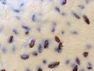 9、葡萄干奶酥,用手按扁，再用擀面杖擀成厚薄均匀的面片。