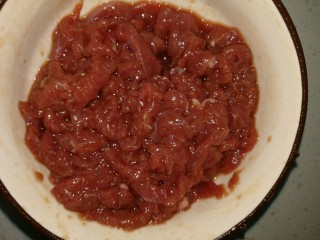 3、炒牛肉,加入生抽和料酒及适量盐拌匀，搅拌时少量多次地加点水