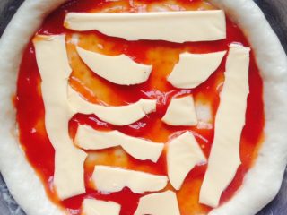 4、蔬菜披萨,把披萨饼底取出在上面涂番茄酱并铺上芝士片