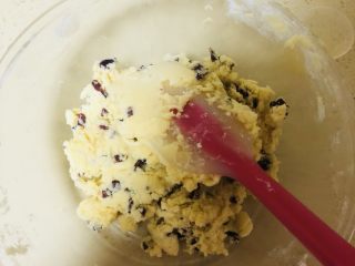 7、蔓越莓饼干,倒入切碎的蔓越莓干,并翻拌均匀成黏面团状态。