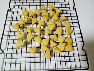 14、南瓜芝麻小饼干,戴上隔热手套取出烤盘，把饼干小心的倒在烤网上晾凉。