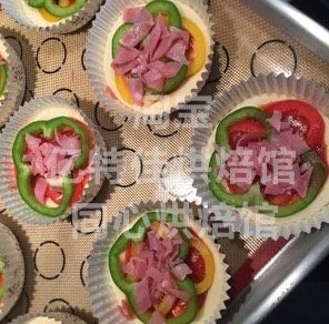 4、自制迷你披萨,然后放两片彩椒切片，彩椒不要切得太厚，太厚不容易烤熟还会出水，再撒上火腿切片