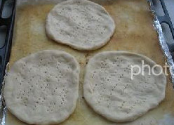 1、水果批萨,发面团分成三份，每份压平，表面刷上油，上面扎些小孔，进行二次发酵