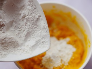 5、烤箱低油版奶香烤南瓜芝麻饼,然后分多次加入糯米粉，搅拌均匀后揉成不粘手的面团。