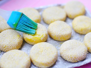 10、烤箱低油版奶香烤南瓜芝麻饼,将小饼放入烤盘中，里外刷一层油。