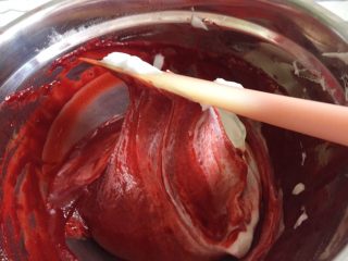 11、覆盆子红丝绒蛋糕,再取三分之一蛋白糊与红丝绒蛋黄糊充分溶合，手法尽量轻柔，避免消泡，将剩下的蛋白糊与蛋黄糊翻拌均匀