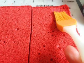 21、覆盆子红丝绒蛋糕,将分成两片的方形蛋糕体平均分成六块小的长方形蛋糕片，蛋糕表面均匀刷酒糖液