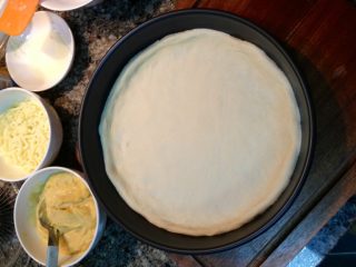 10、HomeMake榴莲披萨（8寸）,将发酵好的面团擀成圆形面皮，放在刷过油（无味的植物油）的披萨烤盘里，用手指从中间往四周轻推整理面皮，将边缘压厚。