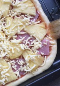 13、夏威夷披萨,用毛刷在披萨饼的边缘刷满橄榄油。