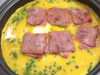 3、简易鸡蛋饼,将培根铺在蛋液上面
