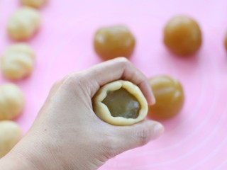 17、广式蛋黄莲蓉月饼,放上馅料，同样用虎口慢慢往上推，直至完全包裹住馅料收口