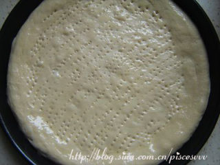 4、香肠披萨 ,将面饼放入事先抹油的披萨盘中，用叉子在面饼上叉些小洞以防烘烤是饼底鼓起