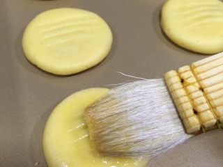 14、肉松饼干,刷上鸡蛋液，入预热好的烤箱中层，上下火180度，烤15分钟左右，至饼干上色即可。