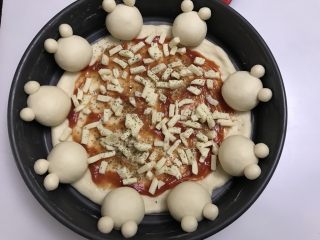 12、可爱小熊披萨,抹一层番茄酱，撒可达怡调味料，然后放一层瑞富杰马苏里拉芝士。我其实芝士放的比较少，一包都没放完，大家可以多多的放。